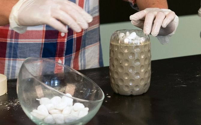 Do butelki wlej masę betonową, a następnie włóż szklankę z tworzywa sztucznego, której zewnętrzne ścianki zabezpiecz olejem kuchennym. Upewnij się, że beton dokładnie pokrył całą przestrzeń pomiędzy ściankami butelki i szklanki. Dociąż szklankę, aby uzys.