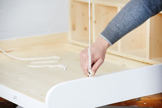 Teraz przykręć śruby oczkowe do boków przewijaka: najpierw nawierć otwór cienkim wiertłem (1-2 mm) przy użyciu akumulatorowej wiertarko-wkrętarki z udarem Bosch PSB 18 LI-2, a następnie przykręć śrubę ręką, aż będzie na odpowiednim miejscu.