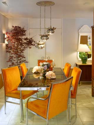 Nowoczesny, szklany stół i piękne kolorowe, tapicerowane welurem krzesła są najważniejszą częścią tej jadalni