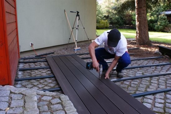 Deski na długości spinamy za pomocą klipów łączących, które przykręcamy do płaskiego podłoża.