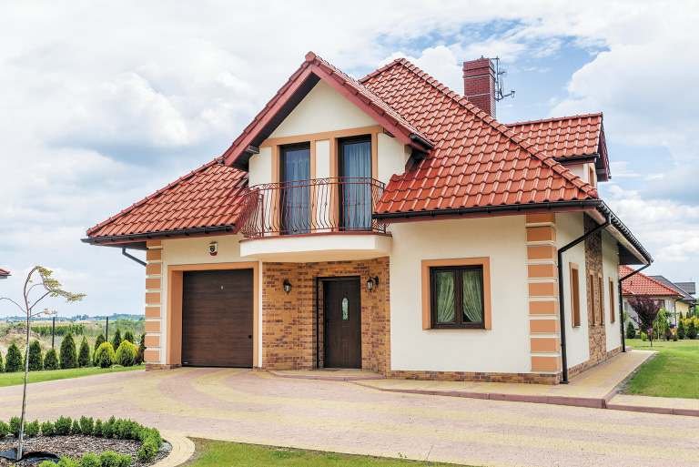 Do domu w stylu tradycyjnym pasuje brama garażowa w kolorze dobranym nie tylko do stolarki okiennej i drzwiowej, ale także do koloru dachu