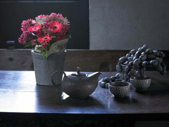 Kolorowe kwiaty pasują do stonowanej aranżacji stołu.
