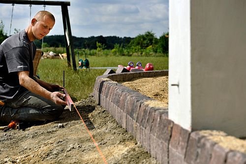 Ważny etap prac to dokładne pomiary. Podczas układania elementów brzegowych wykonawca nie rozstaje się z poziomicą i metrówką.