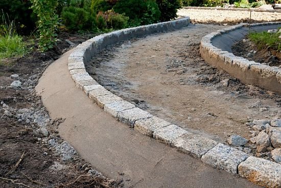 Ścieżka ogrodowa wymaga prawidłowego obramowania. Można wykorzystać do tego elementy brzegowe lub – jak na zdjęciu, np. stabilnie osadzoną kostkę granitową.