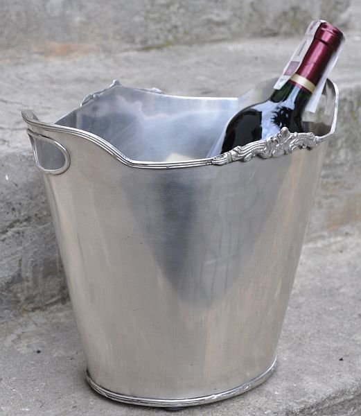Pojemnik Elegance na wino lub szampana jest wykonany z mosiądzu krytego cyną. Do pojemnika można włożyć lód, aby wino, które jest w nim przechowywane, było schłodzone. Wymiary: 23x29 cm. Cena 145 zł
