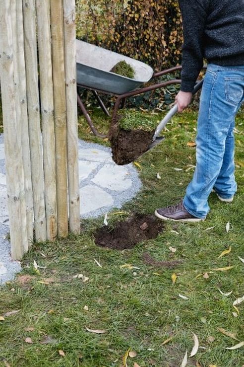 Postaw pale na zewnątrz konturu wypełnionego płytami - będą pełnić funkcję parawanu i zapobiegać zbytniemu rozprzestrzenianiu się wody. Aby zwiększyć stabilność konstrukcji, wbij pale młotem kowalskim bezpośrednio w ziemię na głębokość około 50 cm.