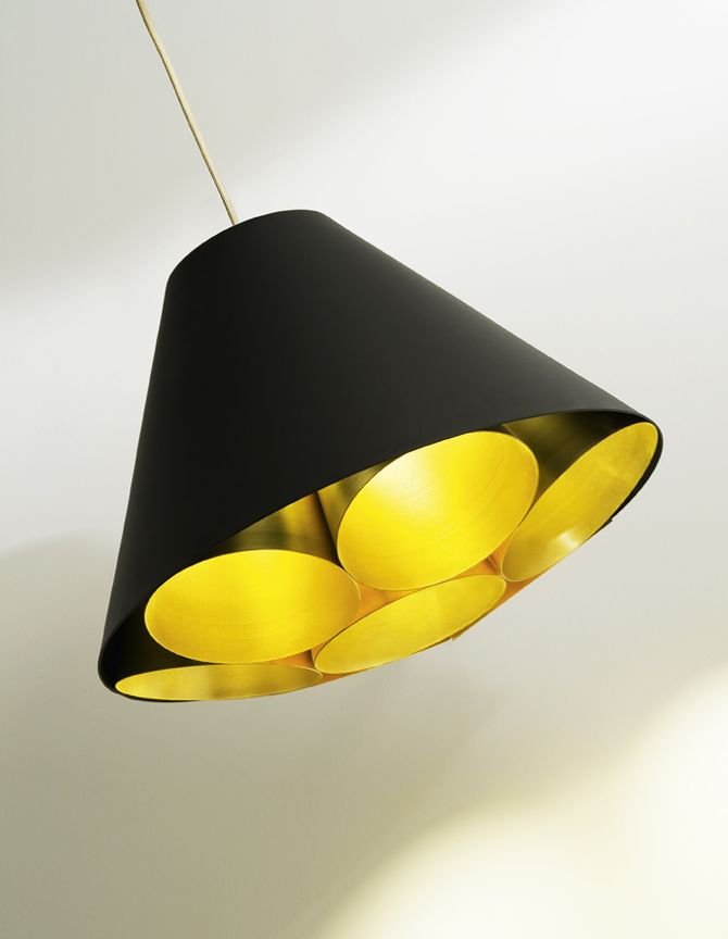 Lampa LGTM projektu Carla Hagerlinga ma formę  metalowego stożkowego klosza (białego albo czarnego, do wyboru), w którym kryje się siedem reflektorków w oprawach z aluminium w złotym kolorze.