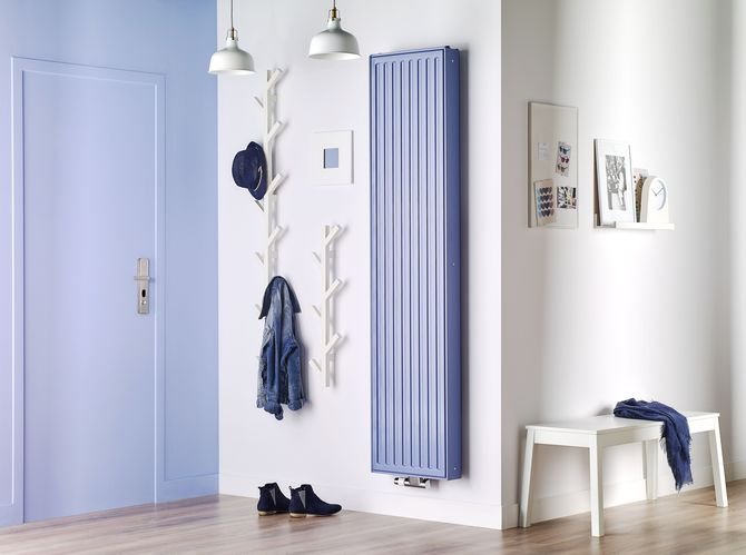 W minimalistycznym przedpokoju kolor grzejnika nawiązuje do stylu drzwi.