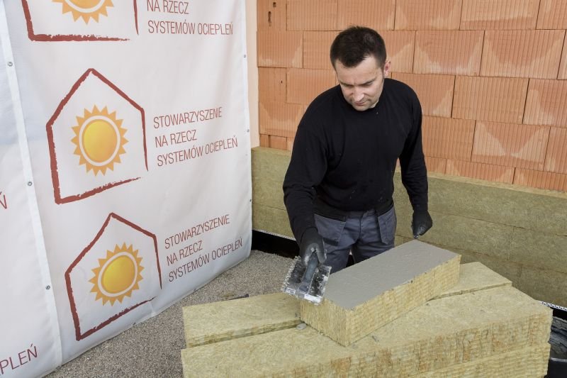 Nakładanie zaprawy klejowej na powierzchnię płyty ociepleniowej z wełny mineralnej; fot. SSO