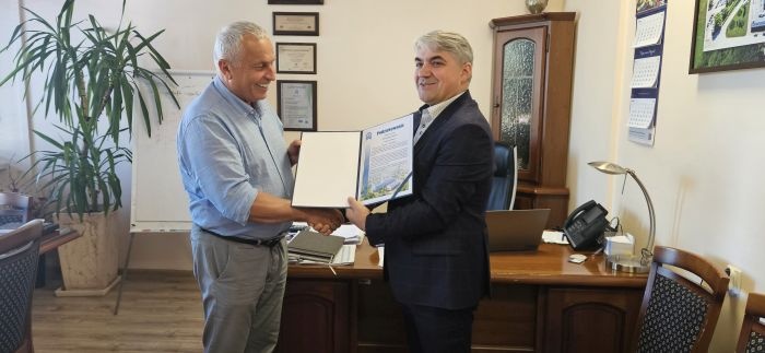 dwóch mężczyzn pokazuje dyplom
