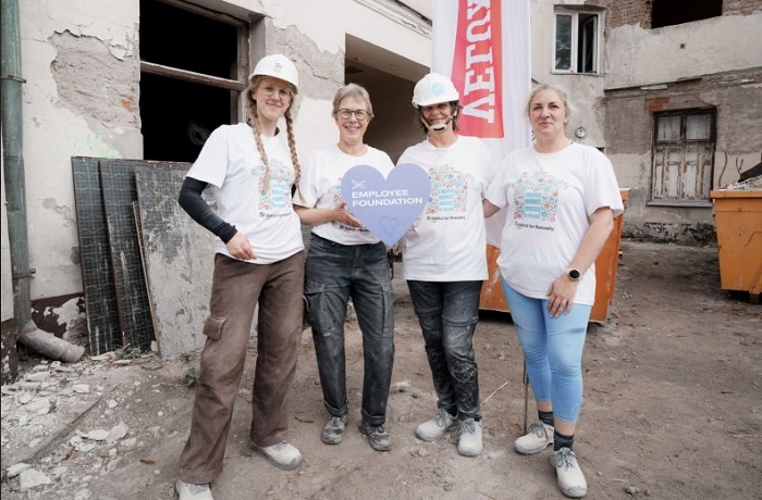 czwórka osób stoi przed remontowanym budynkiem