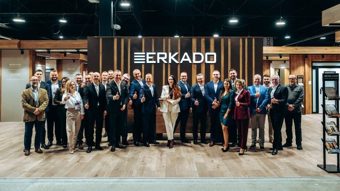 zdjęcie grupowe pracowników Erkado pod logo firmy