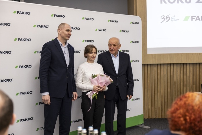 wręczenie kwiatów i trzy osoby pozujące do zdjęcia