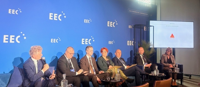 prelegencji na europejskim kongresie gospodarczym na tle niebieskiej ściany