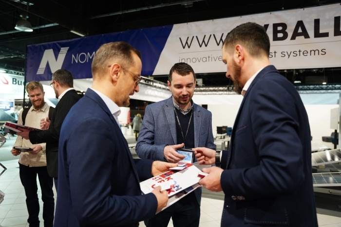 trzech mężczyzn rozmawia podczas targów