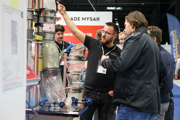 mężczyzna prezentuje drugiemu produkt na targach