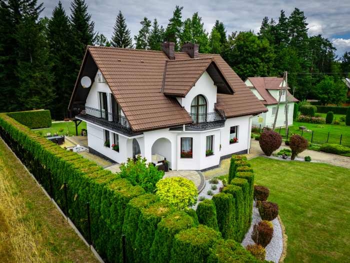 domek w dworkowym stylu wśród zieleni